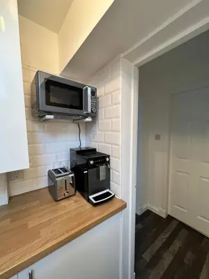 a kitchen with a microwave and a television on a counter at Very Central, Charlotte Square, near the Castle in Edinburgh