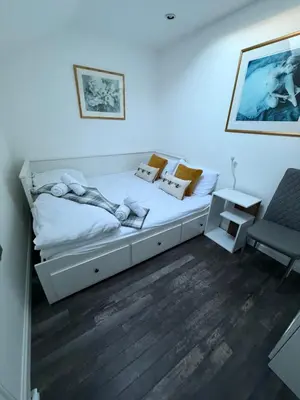 a bedroom with a large white bed and a chair at Very Central, Charlotte Square, near the Castle in Edinburgh