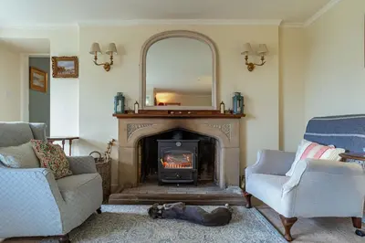 a living room with a fireplace and a mirror at Kenmure Kennels in New Galloway