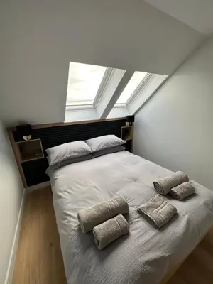 a bedroom with a bed with pillows and a window at Laurieston Penthouse in Grahamston