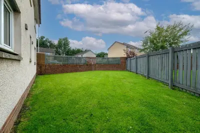 a large backyard with a fence and green grass at Pure Apartments Commuter- Dunfermline South in Fife