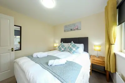 a bedroom with a large white bed with two pillows at Pure Apartments Commuter- Dunfermline South in Fife