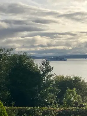 a view of a large body of water with trees at Dunholm Cottage in Skelmorlie