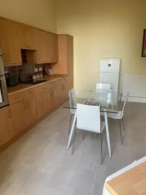a kitchen with a glass table and white chairs at Private Guest Suite in Georgian Townhouse in City Centre in Edinburgh