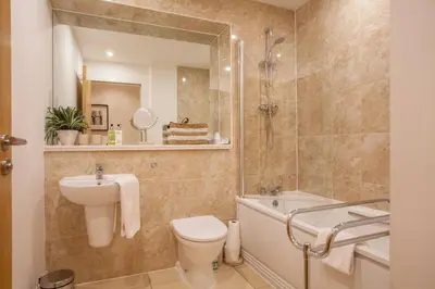 a bathroom with a sink and a toilet and a bath tub at 1 Bedroom Flat in the Heart of Merchant City in Glasgow