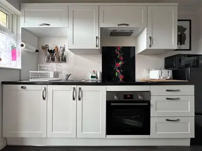 a kitchen with white cabinets and a black oven at FINN VILLAGE 