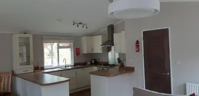 a kitchen with white cabinets and a counter top at Inverbeg Holiday Park in Luss