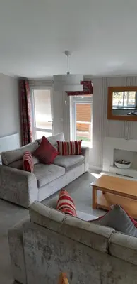 a living room with two couches and a table at Inverbeg Holiday Park in Luss