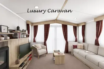 a living room with a couch and a tv at Inverbeg Holiday Park in Luss
