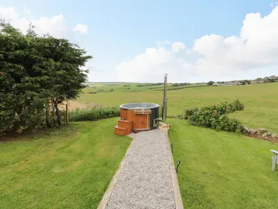 a hot tub in the middle of a field at Greenacres Carriage in Maybole