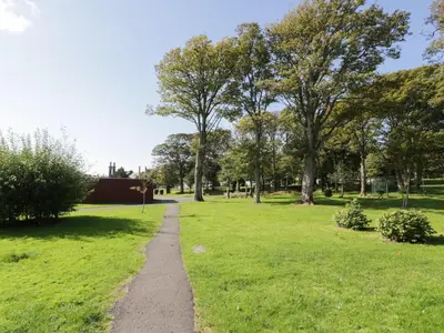 a path through a park with trees and grass at Silverbells in Millport