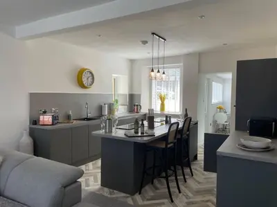 a kitchen with a table and chairs in a room at Fantastic home in Brightons, Falkirk. in Polmont