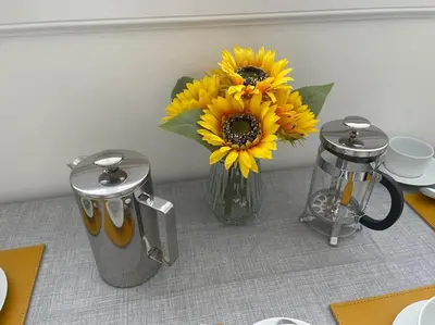 a vase with sunflowers in it on a table at Fantastic home in Brightons, Falkirk. in Polmont