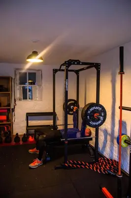 a room with a gym with a person laying on the floor at Ash, Birch and Rowan Self Catering Cabins in Onich