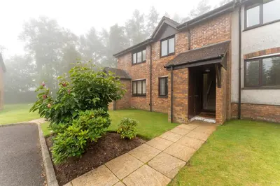 a brick house with a courtyard with a garden at 33 Dunbar Court Gleneagles Village in Auchterarder