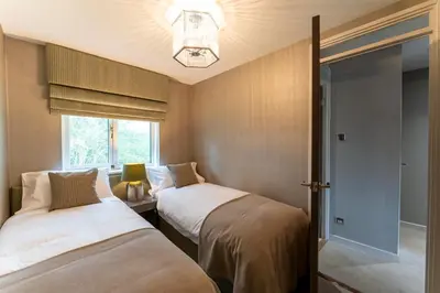 two beds in a small room with a window at 33 Dunbar Court Gleneagles Village in Auchterarder