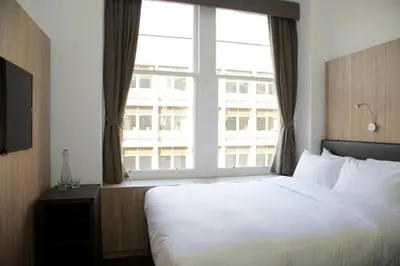 a bedroom with a large bed and a large window at The Z Hotel Glasgow in Glasgow
