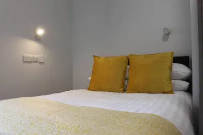 a bedroom with a bed with yellow pillows at The Arches The Wee Yin in Stirling