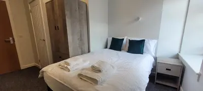 a bedroom with a white bed with towels on it at The Arches The Wee Yin in Stirling