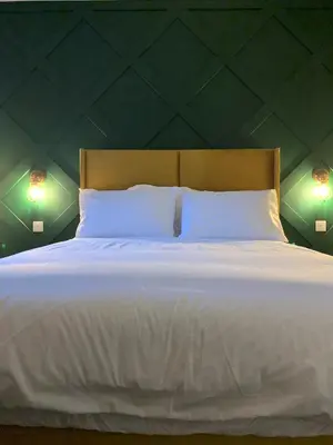 a large white bed with two lights on the wall at Hillview in Oban