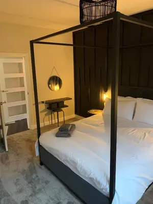 a bedroom with a black canopy bed with a table at Hillview in Oban