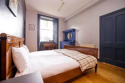 a bedroom with a bed and a blue door at JOIVY Splendid Apartment near Haymarket in Edinburgh