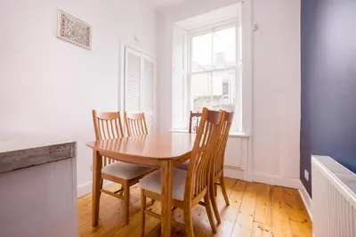 a dining room with a wooden table and chairs at JOIVY Splendid Apartment near Haymarket in Edinburgh