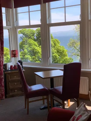a room with a table and two chairs and a window at Chandlers Country House in Rothesay
