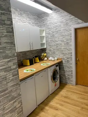 a kitchen with a washer and dryer next to a brick wall at Chandlers Country House in Rothesay
