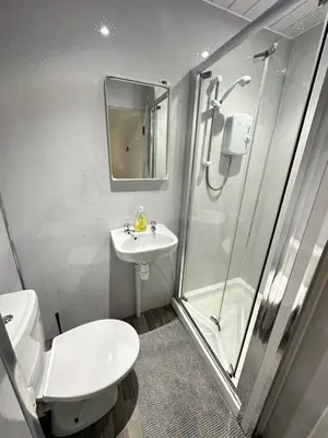 a bathroom with a shower and a toilet and a sink at Rangers GuestHouse in Glasgow