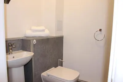 a bathroom with a white toilet and a sink at The Arches - The Big Yin in Stirling