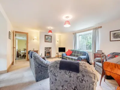 a living room with two couches and a table at Brondeg Lodge in Crarae