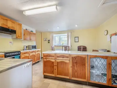 a large kitchen with wooden cabinets and a window at Brondeg Lodge in Crarae