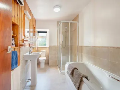a bathroom with a sink and a tub and a toilet at Brondeg Lodge in Crarae