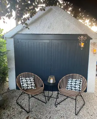 two chairs and a table in front of a garage at Hillview Cottage in Edinburgh