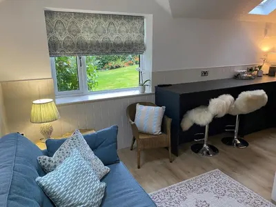 a living room with a blue couch and a window at Hillview Cottage in Edinburgh
