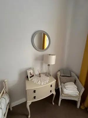 a white dresser with a lamp and a mirror at Castle Brae Apartment in Stirling