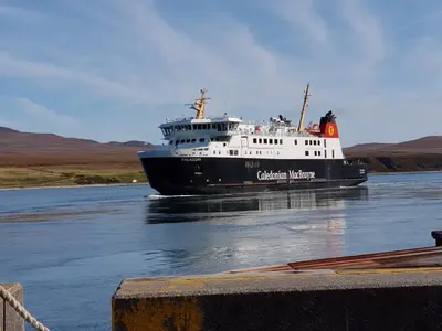 a black and white boat in the water at Seal Cottage in Portnahaven