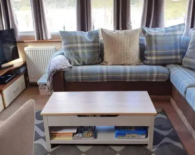 a living room with a couch and a coffee table at Loch Earn Holiday Home in Saint Fillans