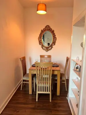 a dining room table with two chairs and a mirror at Royal Apartments Edinburgh in Edinburgh