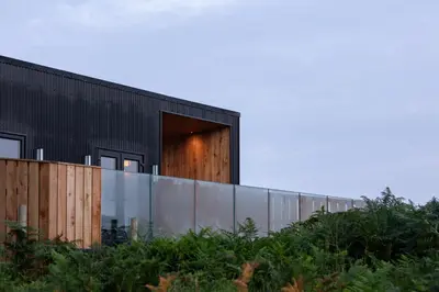 a black house with a glass wall at The Black Cabin Oban in Oban