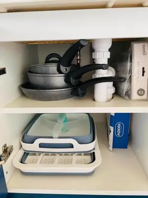 a shelf with a pan and a sink and a pot holder at Beach House Pods in Dunoon