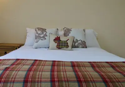 a bed with white sheets and pillows on it at Caledonian - Charming Central 1 Bed Flat in Edinburgh