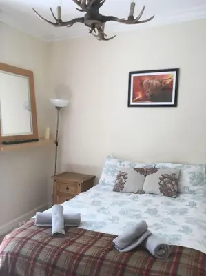 a bedroom with a bed and a picture on the wall at Caledonian - Charming Central 1 Bed Flat in Edinburgh
