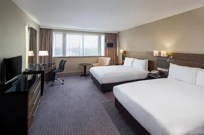 a hotel room with two beds and a television at Crowne Plaza Glasgow by IHG in Glasgow