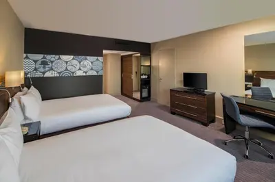 a large hotel room with a bed and a desk at Crowne Plaza Glasgow by IHG in Glasgow