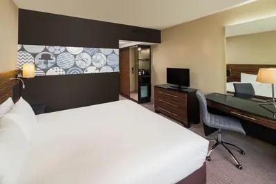 a hotel room with a large bed and a desk at Crowne Plaza Glasgow by IHG in Glasgow