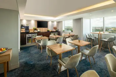 a restaurant with tables and chairs and a tv at Crowne Plaza Glasgow by IHG in Glasgow