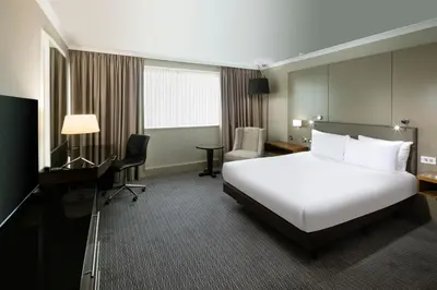 a hotel room with a white bed and a desk at Crowne Plaza Glasgow by IHG in Glasgow