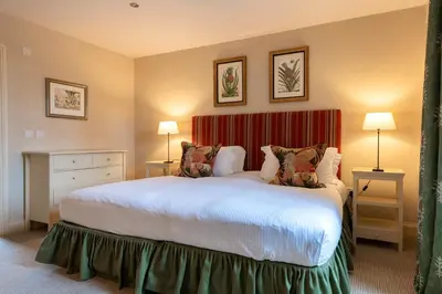 a bedroom with a large bed and two lamps at Isle of Eriska Hotel Spa & Island in Benderloch